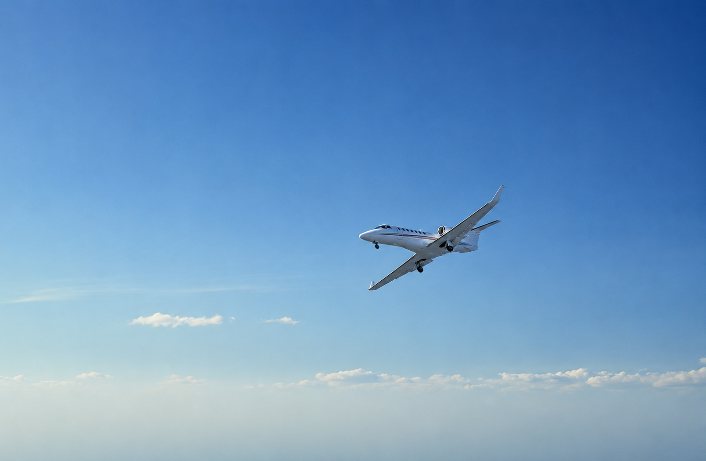 Private jet flying through blue sky